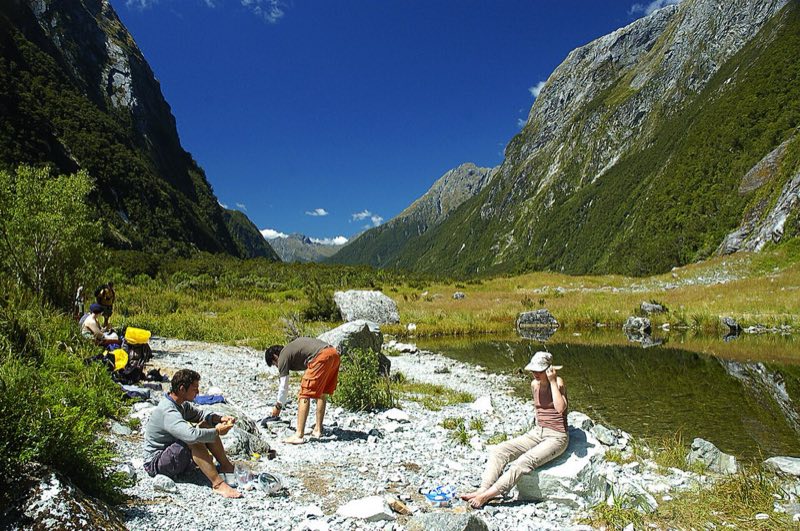 Hikers resting in an alpine valley on New Zealand's Milford Track